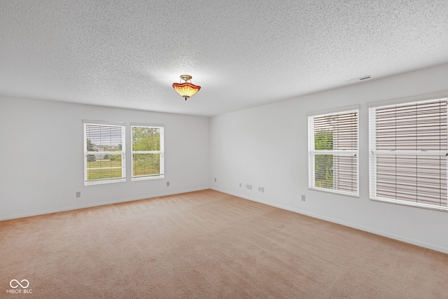 carpeted empty room with a textured ceiling