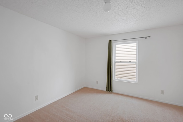 unfurnished room with light colored carpet and a textured ceiling