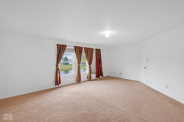 carpeted spare room featuring a textured ceiling