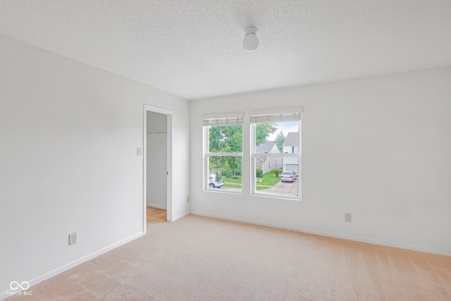 carpeted spare room with a textured ceiling