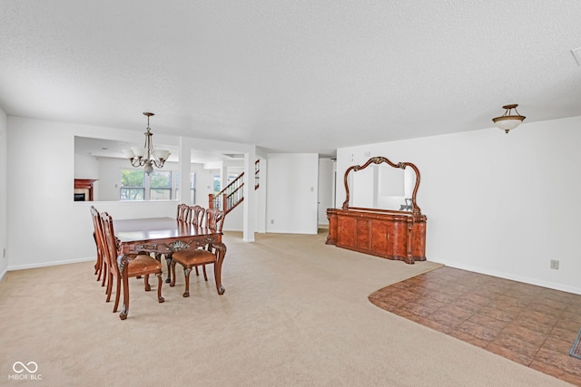 carpeted dining room featuring an inviting chandelier and a textured ceiling