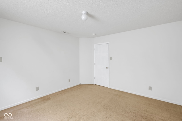 carpeted empty room featuring a textured ceiling