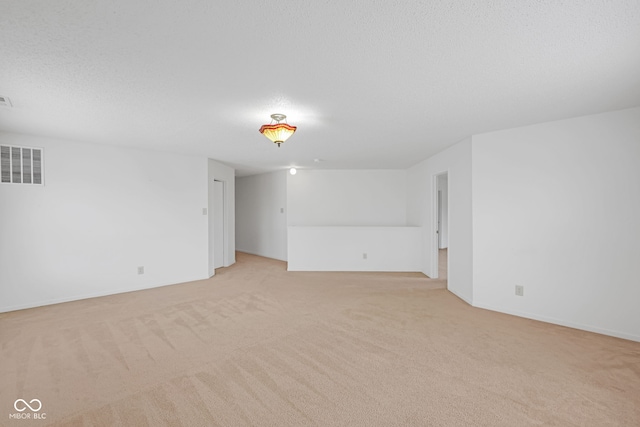 carpeted empty room featuring a textured ceiling