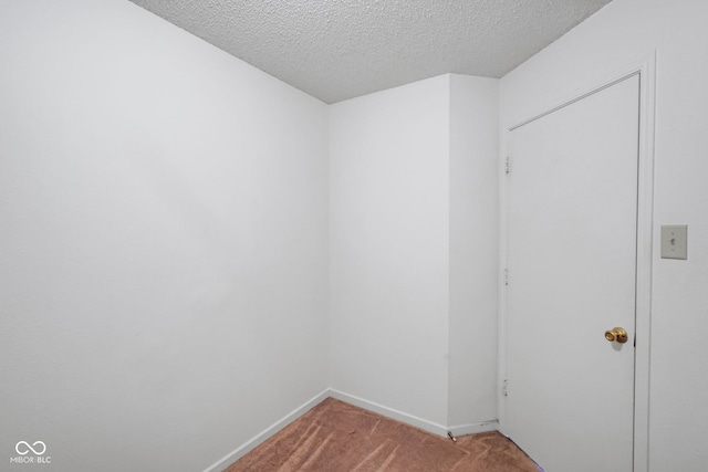 carpeted empty room featuring a textured ceiling