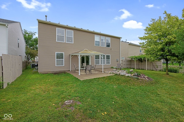 rear view of house featuring a yard and a patio