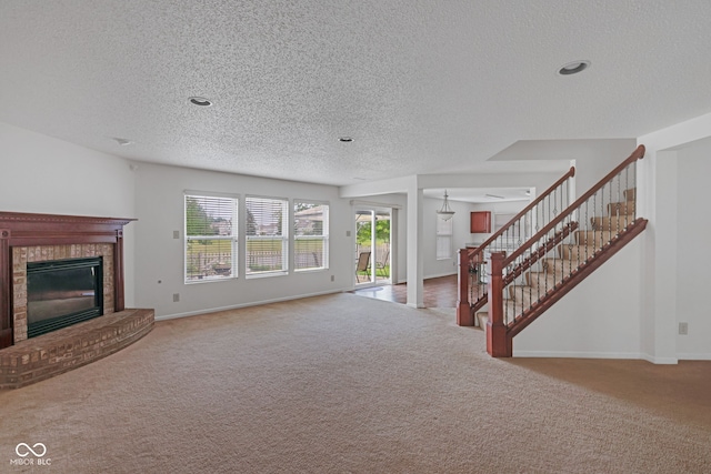 unfurnished living room featuring a fireplace, a textured ceiling, and carpet