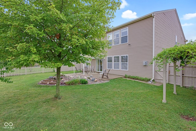 rear view of property featuring a yard and a patio area