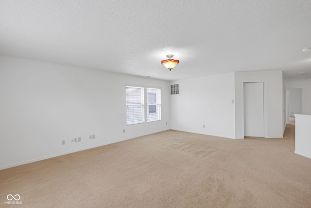 carpeted empty room with a textured ceiling