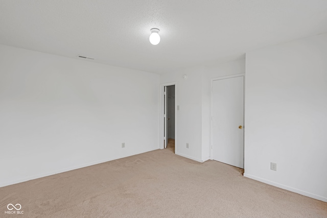 carpeted spare room featuring a textured ceiling