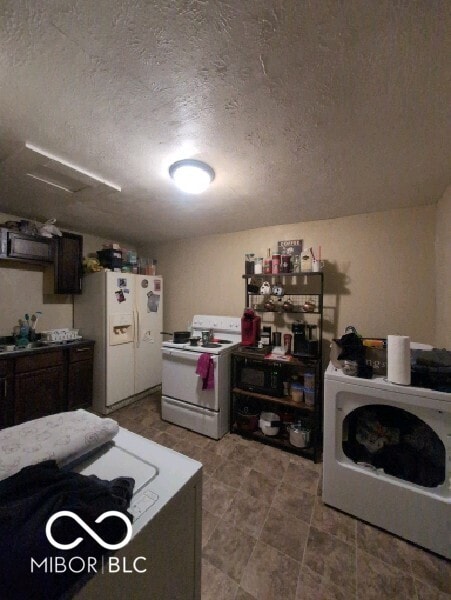 kitchen with dark brown cabinets, tile patterned floors, white appliances, and a textured ceiling