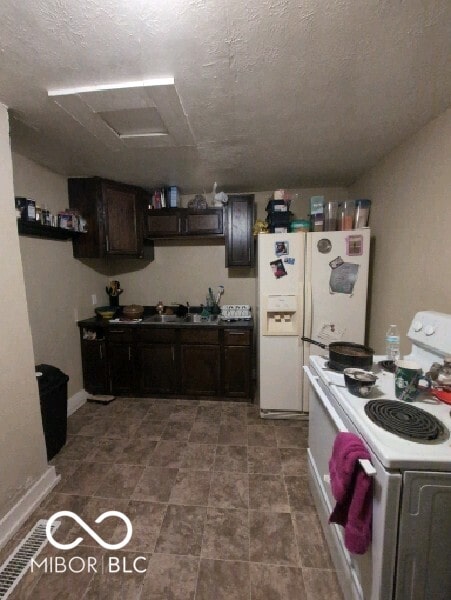 kitchen featuring sink, dark brown cabinets, tile patterned flooring, and white appliances