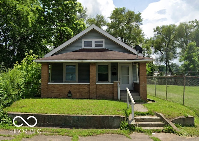 2221 Langley Ave, Indianapolis, IN 46218 - bungalow-style house with a porch, brick siding, and a shingled roof