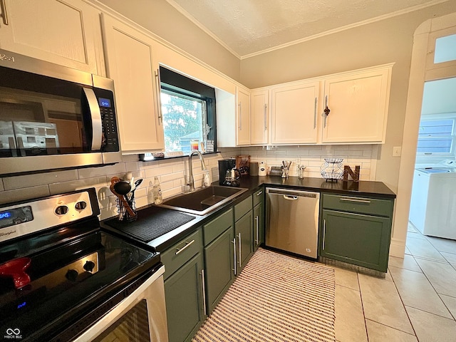 kitchen featuring white cabinets, green cabinets, appliances with stainless steel finishes, sink, and washing machine and dryer