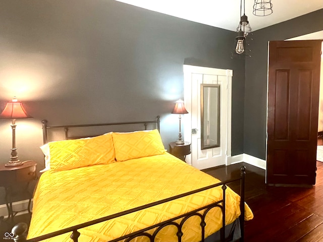 bedroom with dark hardwood / wood-style flooring