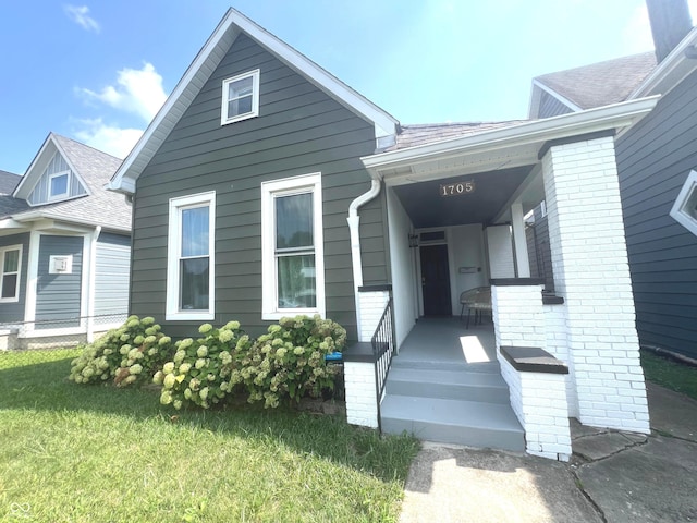 view of front of house featuring covered porch and a front lawn