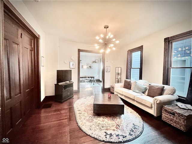 living room with an inviting chandelier and dark hardwood / wood-style flooring