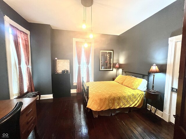 bedroom with dark wood-type flooring, multiple windows, and ceiling fan