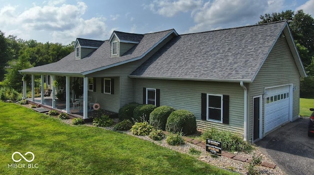 view of side of home featuring a garage, driveway, a shingled roof, and a lawn