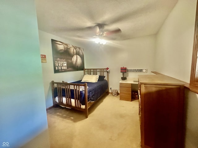 bedroom featuring light carpet, ceiling fan, and a textured ceiling