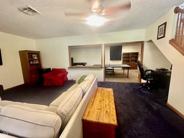 carpeted living room with ceiling fan, a textured ceiling, visible vents, and baseboards