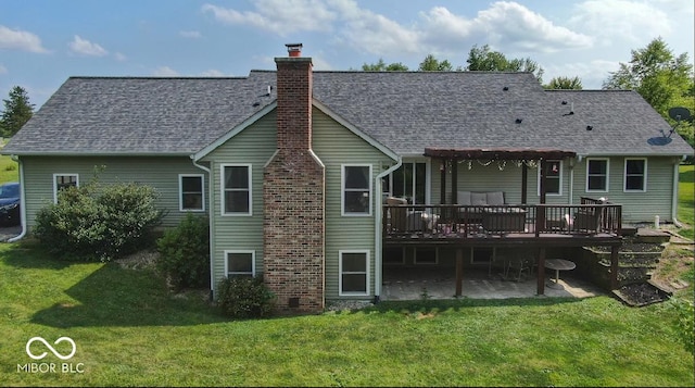 back of house with a patio area, a shingled roof, a lawn, and a wooden deck