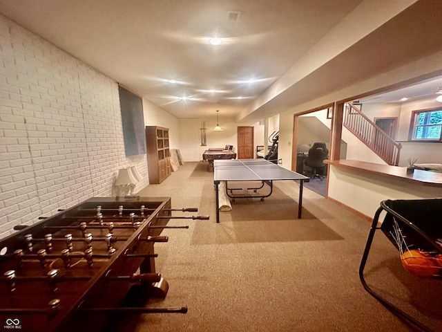 playroom featuring carpet, baseboards, and brick wall