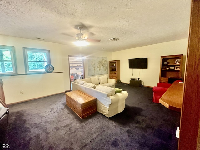 living area featuring carpet flooring, visible vents, and a textured ceiling