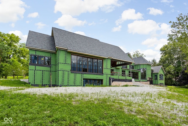 back of property with a shingled roof