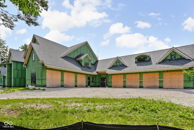 view of front of property with a shingled roof, gravel driveway, and an attached garage