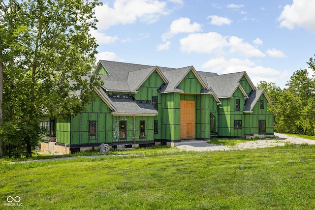 view of front of house with a front lawn and roof with shingles