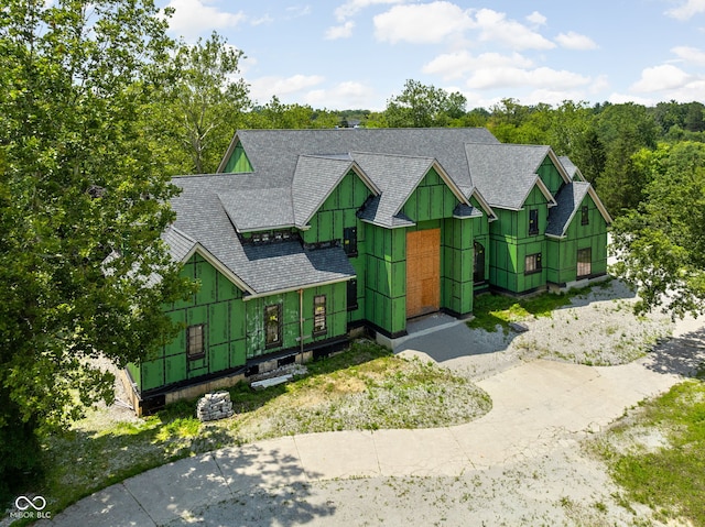 view of front of house with a shingled roof and concrete driveway