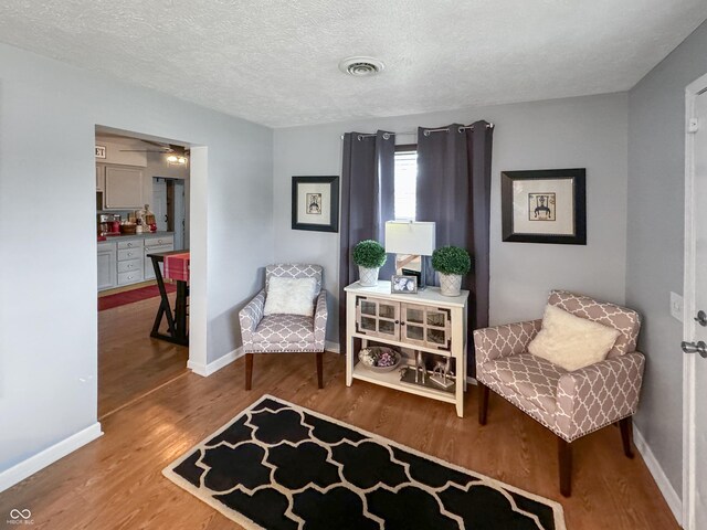 sitting room featuring a textured ceiling and light hardwood / wood-style floors