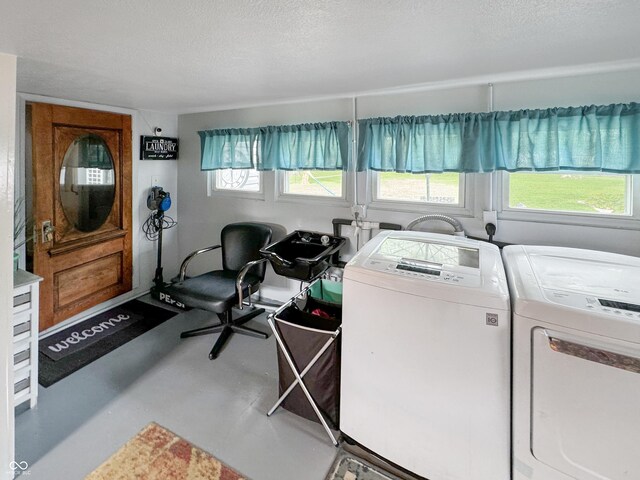 washroom featuring washer and clothes dryer, a textured ceiling, and a wealth of natural light