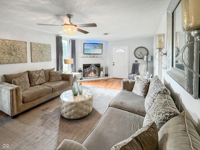 5647 W Mooresville Rd, Indianapolis, IN 46221 - living room with a brick fireplace, hardwood / wood-style flooring, a textured ceiling, and ceiling fan