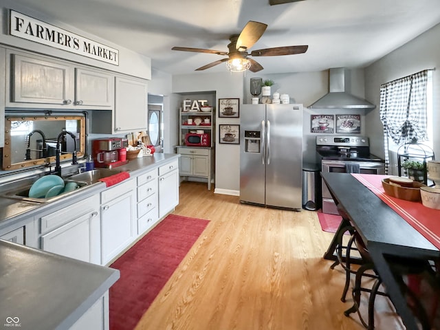5647 W Mooresville Rd, Indianapolis, IN 46221 - kitchen featuring sink, white cabinets, stainless steel appliances, plenty of natural light, and wall chimney range hood