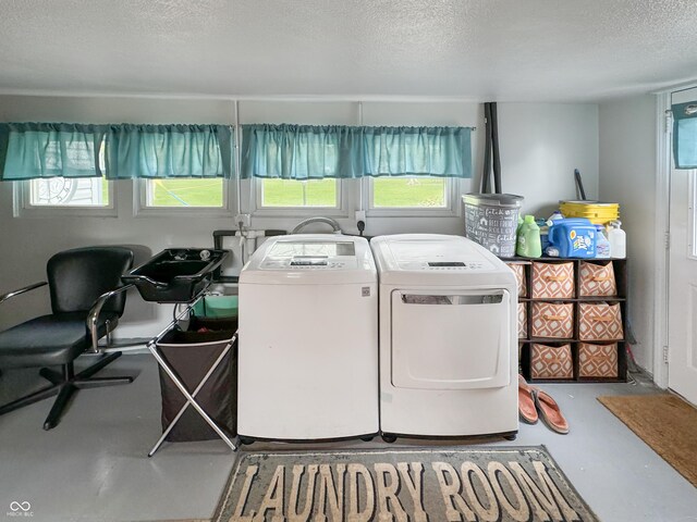 laundry room featuring plenty of natural light, a textured ceiling, and washing machine and clothes dryer