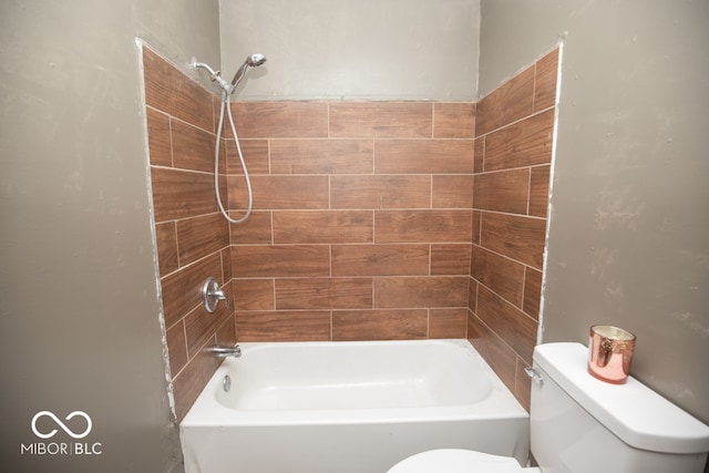 bathroom with toilet and tiled shower / bath