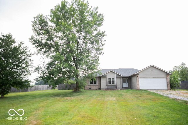 single story home featuring a garage and a front lawn