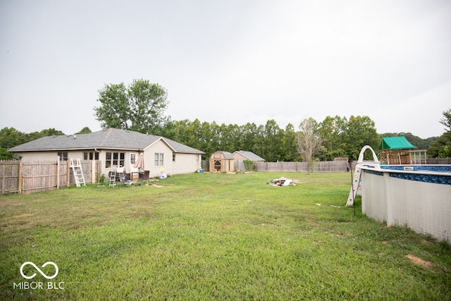 view of yard featuring a playground and a fenced in pool