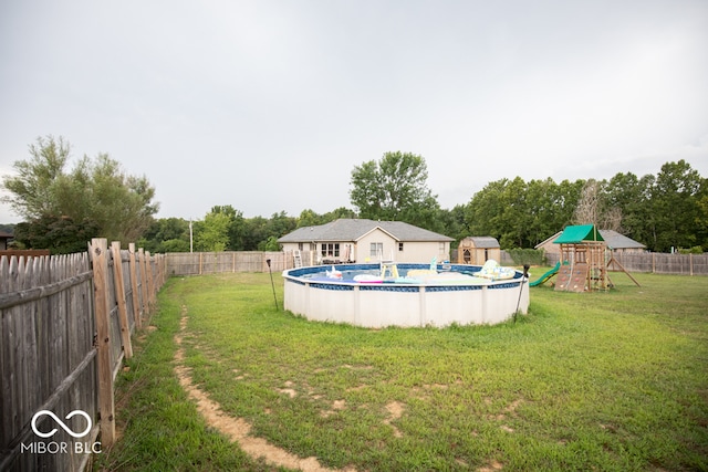 view of yard with a playground and a fenced in pool