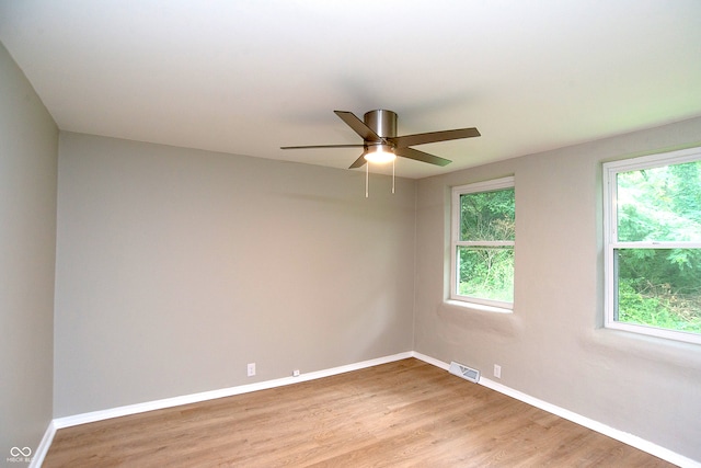 empty room with ceiling fan and light hardwood / wood-style flooring