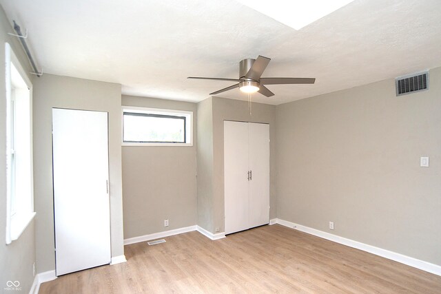 unfurnished bedroom featuring light hardwood / wood-style flooring, a closet, and ceiling fan