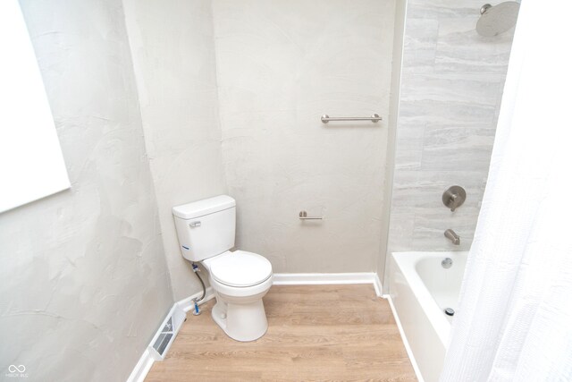 bathroom with toilet, shower / bath combination with curtain, and hardwood / wood-style flooring