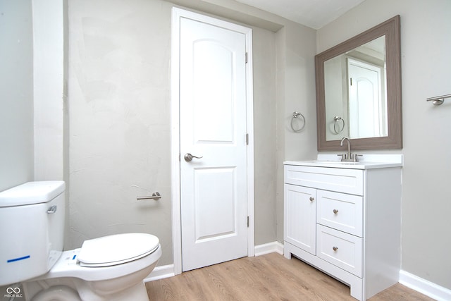 bathroom featuring vanity, toilet, and hardwood / wood-style floors