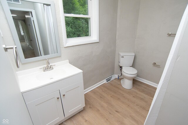 bathroom featuring wood-type flooring, vanity, and toilet