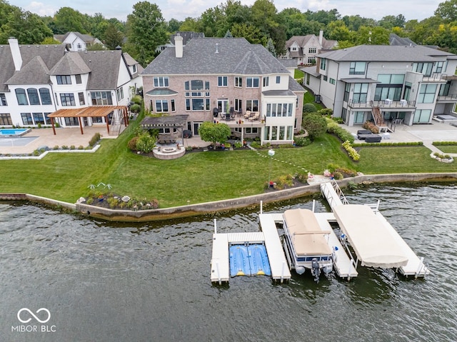 rear view of house with a patio, a water view, and a yard