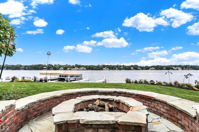 view of patio with a boat dock, a water view, and an outdoor fire pit