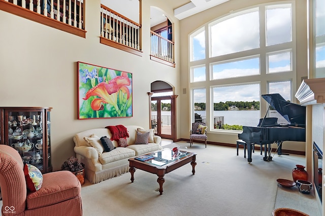 living room featuring a towering ceiling and carpet flooring