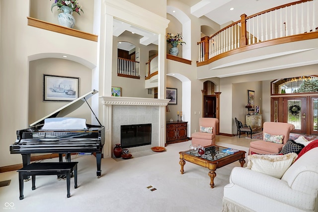 living room featuring carpet, a high ceiling, and a fireplace