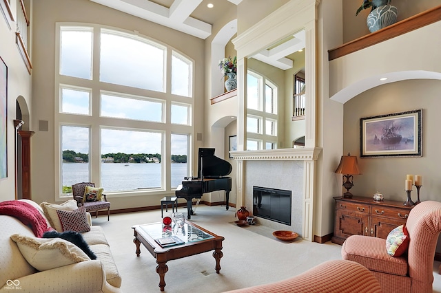 carpeted living room featuring beam ceiling and a high ceiling